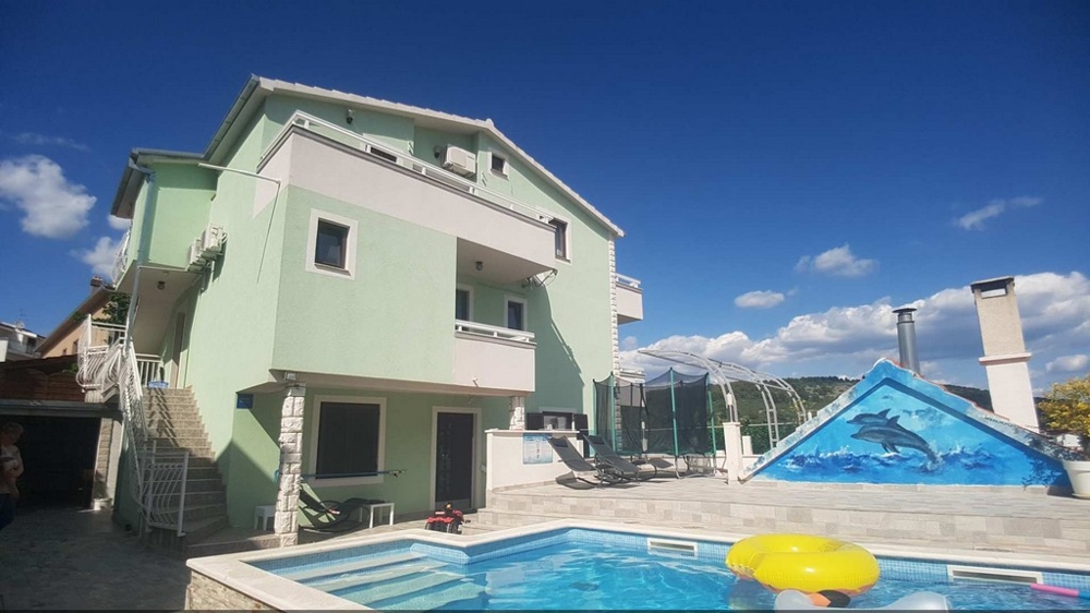 Grünes Haus mit Pool und Poolüberdachung im Hof