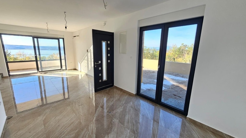 Wohnraum mit Fliesenboden und bodentiefen Fenstern zum Meer - H2197