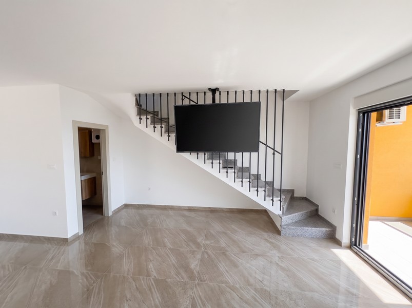 Wohnraum mit Treppe ins Obergeschoss und Zugang zum Bad - H2197