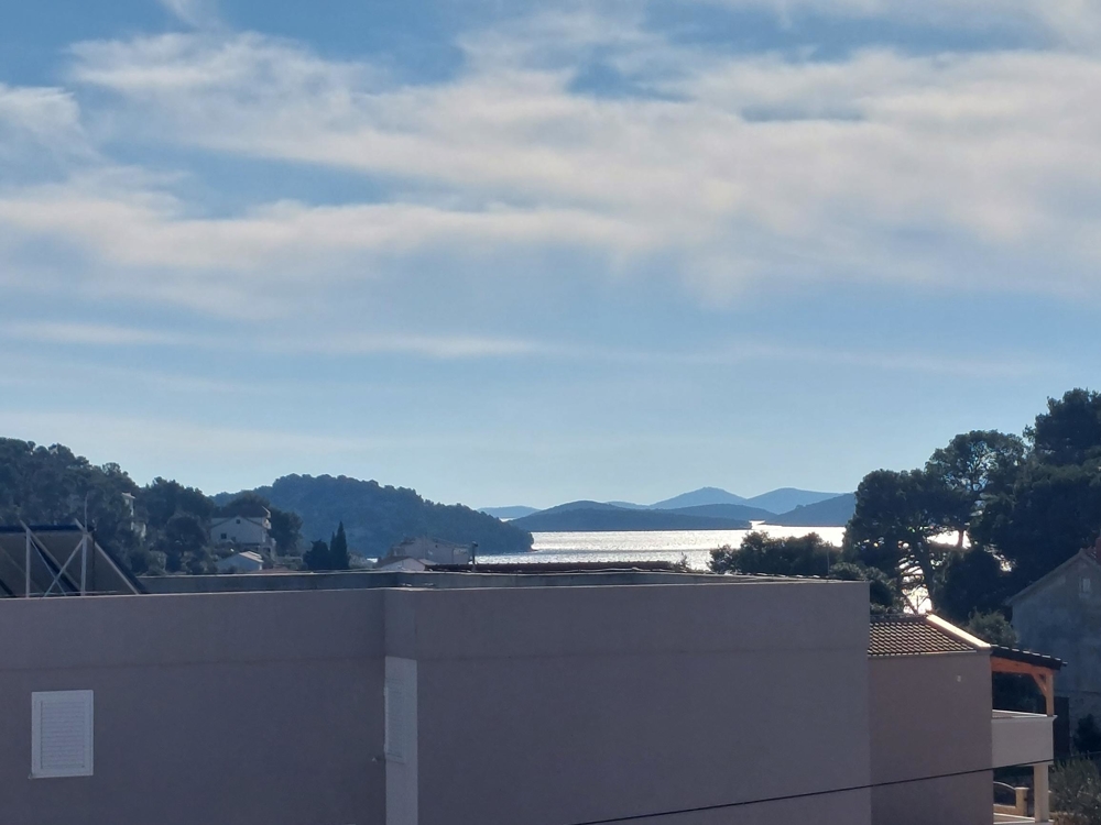 Blick über die Dächer auf die Bucht im Gegenlicht