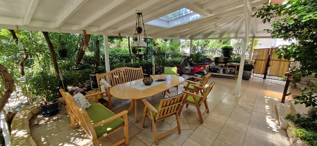Überdachte Terrasse mit Esstisch im Garten