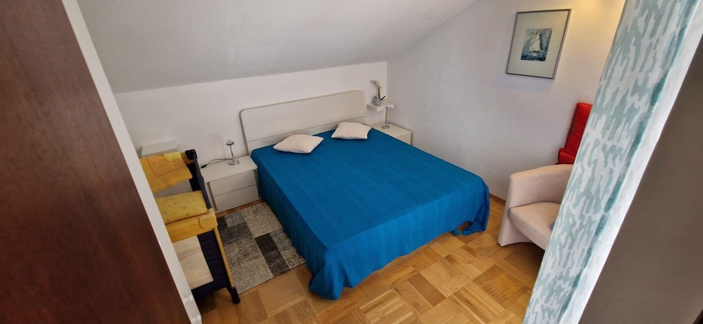 Schlafzimmer mit blauer Tagesdecke