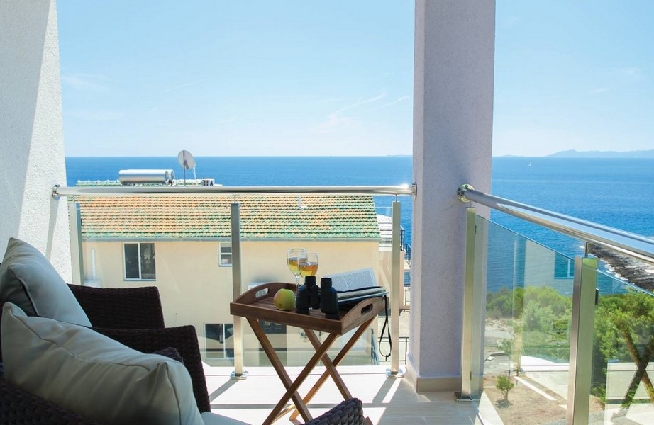 Balkon mit Tablett auf dem Klapptisch und Blick aufs Meer