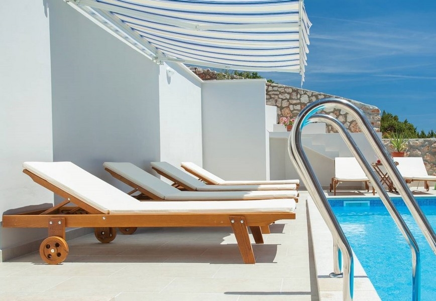 Hochwertige Sonnenliegen am Swimmingpool.
