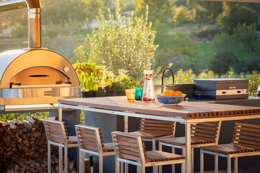 Außenküche mit Pizzaofen und Sitzplätzen