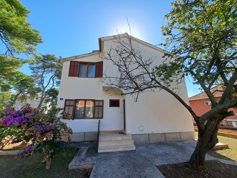 Familienhaus in Kroatien mit weitem Grundstück und weinbewachsener Fassade, angeboten von führendem Immobilienmakler.