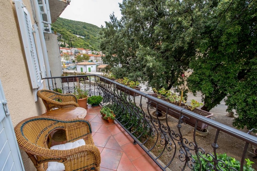 Balkon mit Rattanmöbeln einer kroatischen Immobilie mit Blick auf grüne Landschaft