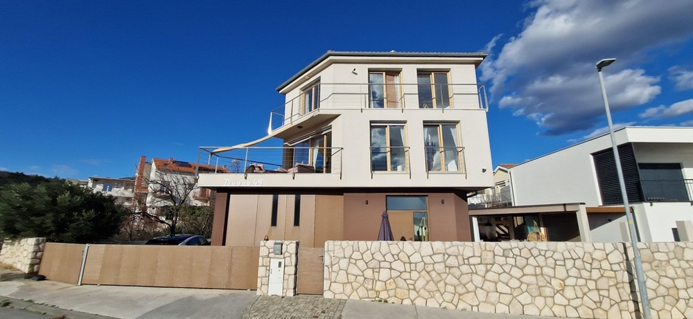 Frontansicht einer modernen Villa in Kroatien mit beiger Fassade und großen Balkonen