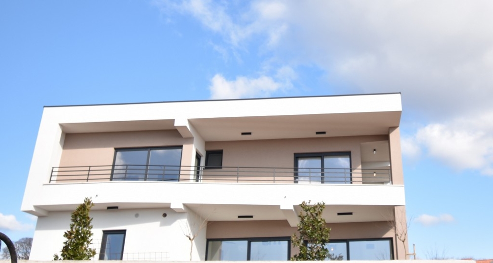 Moderne zweistöckige Villa auf der Insel Krk in Kroatien mit flachem Dach und Balkon.