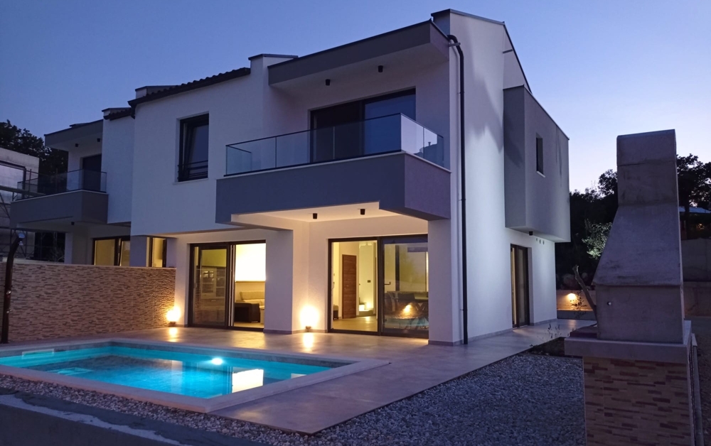 Die beleuchtete Vorderansicht einer modernen Immobilie in Kroatien zeigt die Architektur und den Eingangsbereich.