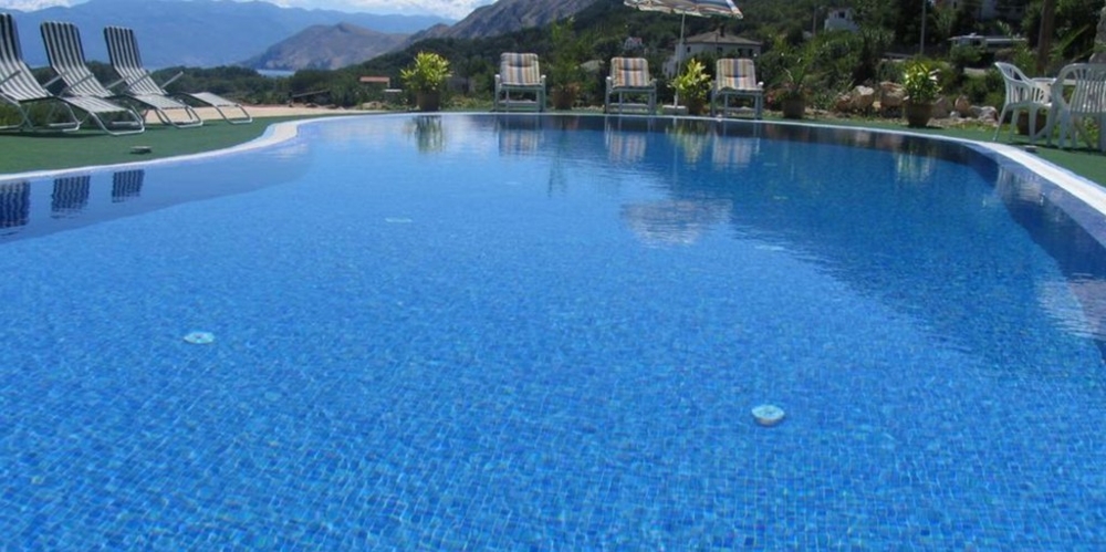 Großer Swimmingpool mit Liegen am Beckenrand