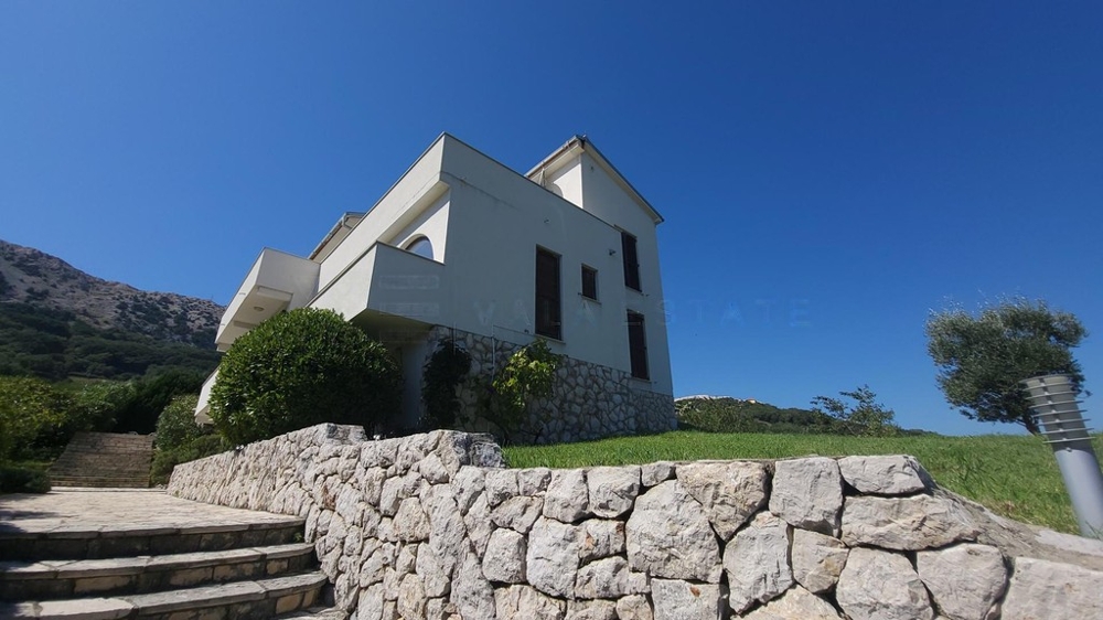 Haus mit Natursteinmauer, Rasen und Treppe