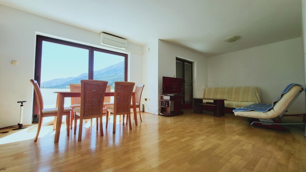 Heller Wohnraum mit Parkett und Blick auf Berge und Meer