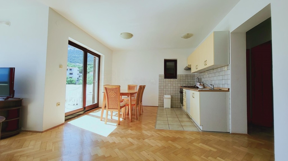 Wohnzimmer mit offener Küchenzeile und Balkontür