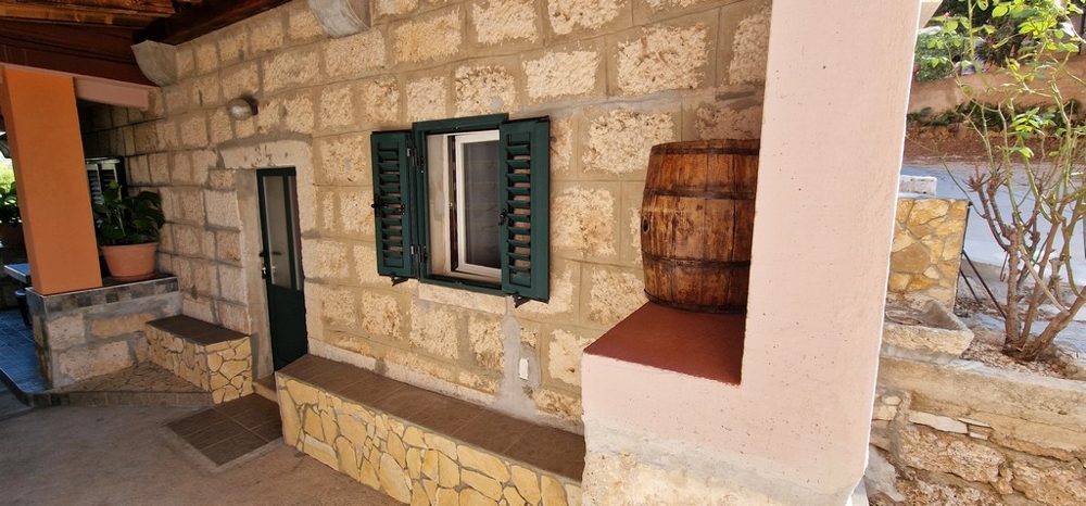 Eingangsbereich aus Naturstein mit Fensterläden
