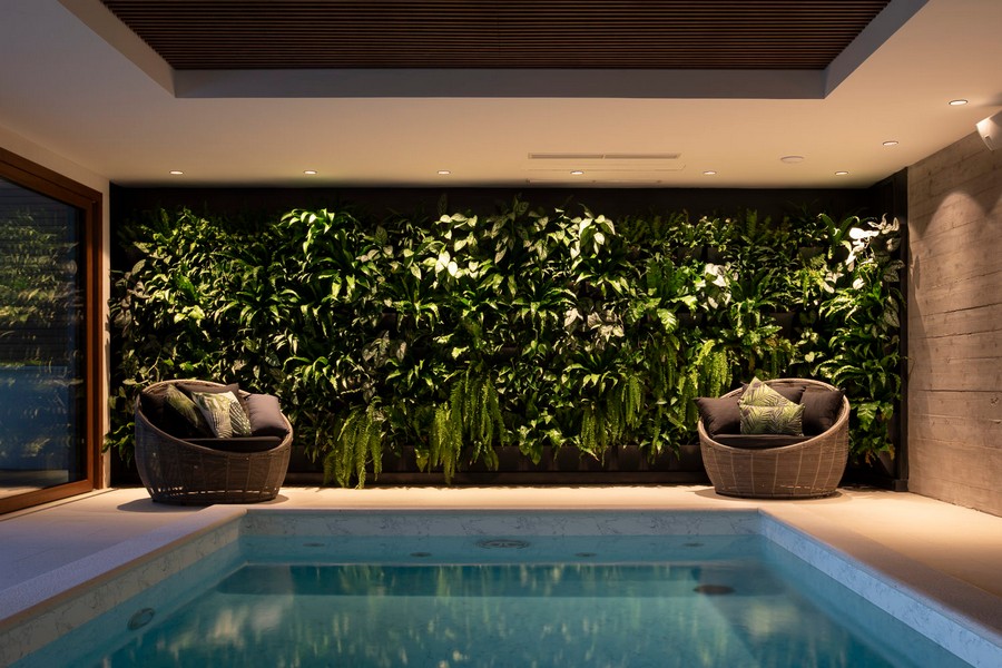 Innenpool mit grüner Pflanzenwand und Sitzbereich