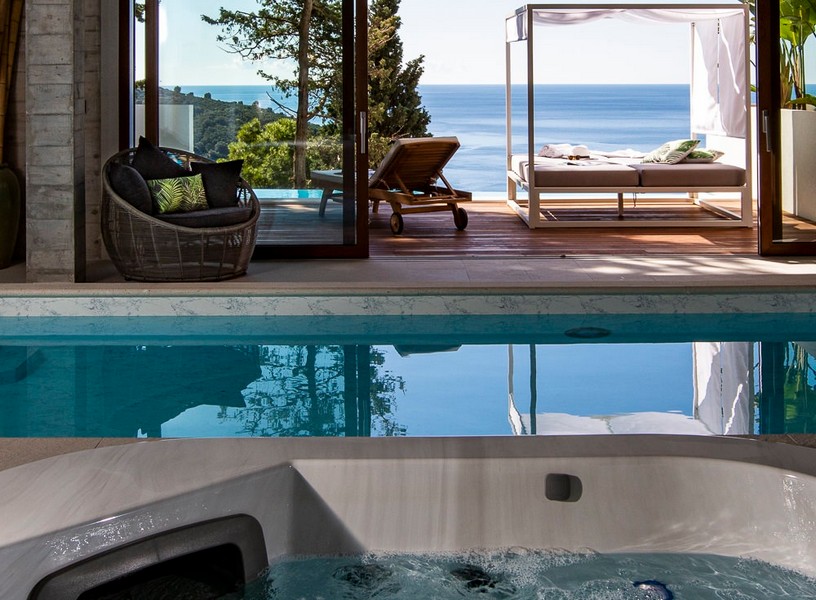 Innenpool mit Whirlpool und Blick auf Sonnenterrasse mit Meerblick