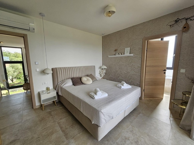 Schlafzimmer mit Doppelbett und Zugang zum Bad