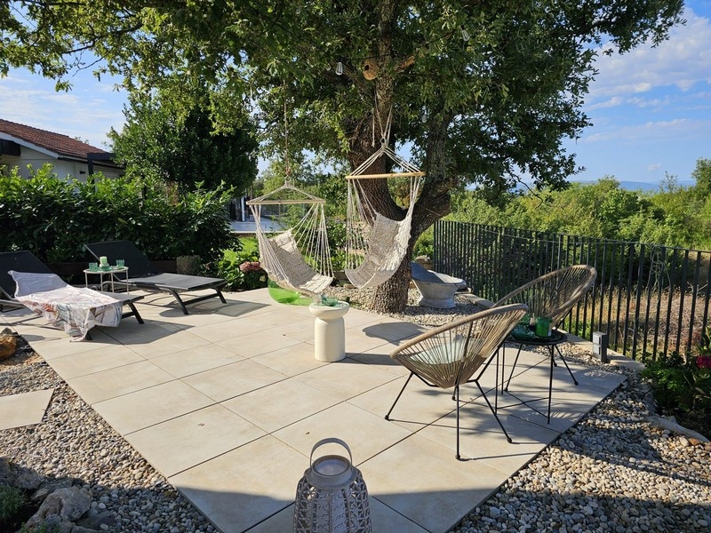 Sonnenterrasse mit Hängesesseln und Gartenblick