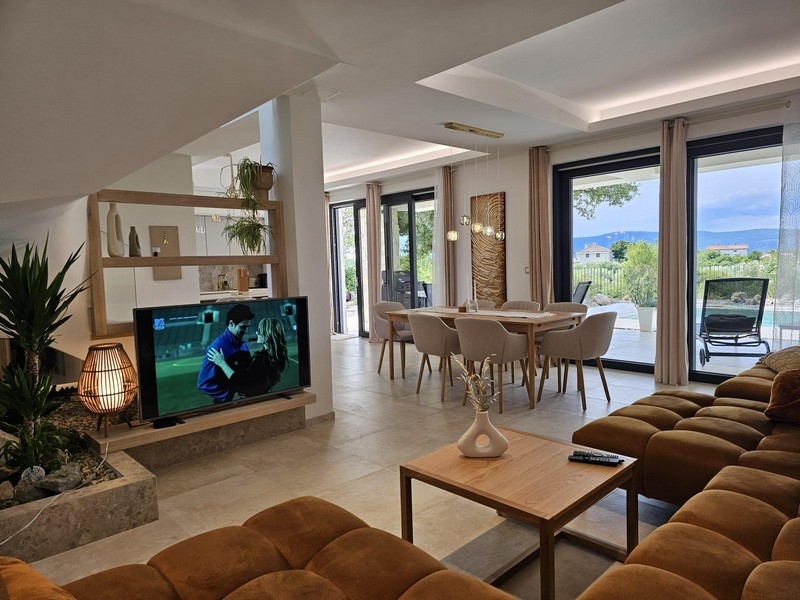 Helles Wohnzimmer mit Essbereich und Blick auf Pool