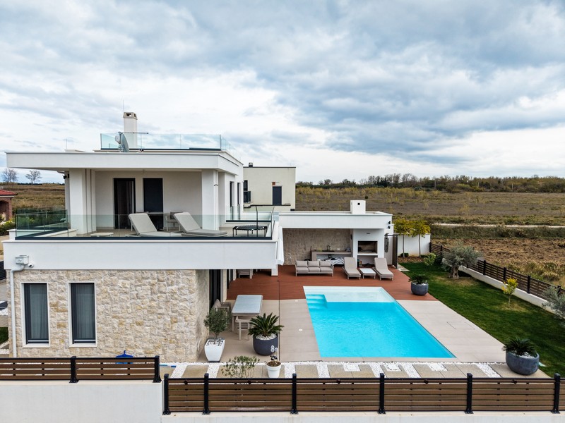 Seitenansicht der Villa mit großer Terrasse und Pool