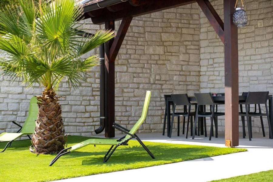 Liegestühle im Gartenteil unter Pergola