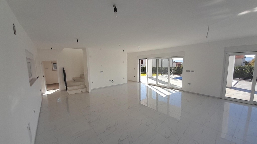 Großzügiger Wohnraum mit Treppe ins Obergeschoss der Villa H3772