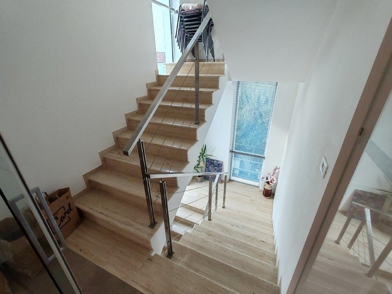 Helles Treppenhaus mit Natursteinboden