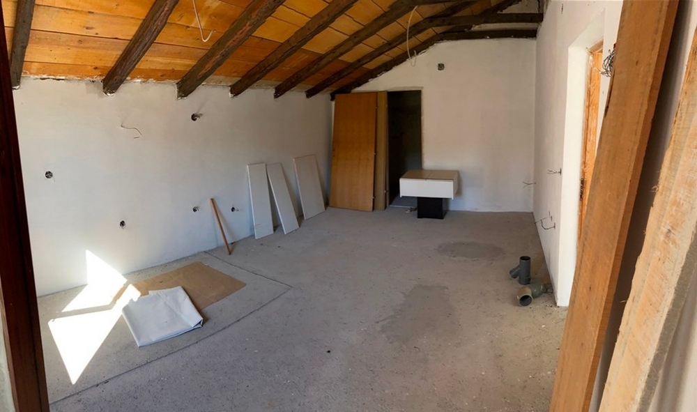 Rohbau Innenraum mit sichtbarer Dachkonstruktion