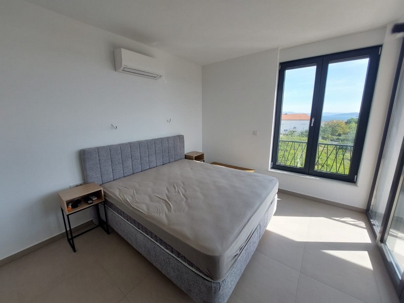 Schlafzimmer mit großen Fenstern und Klimaanlage