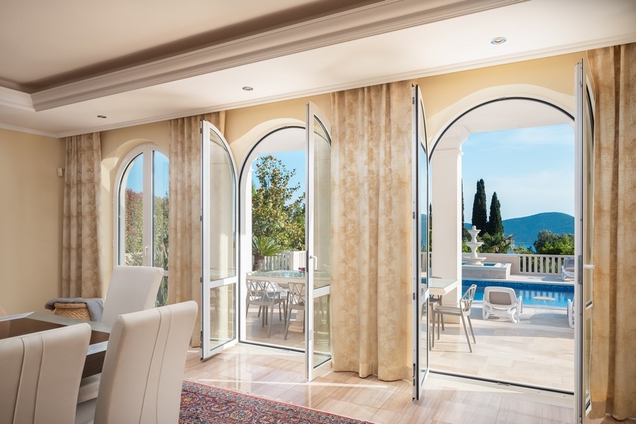 Wohnbereich mit großen Fenstern und Poolblick