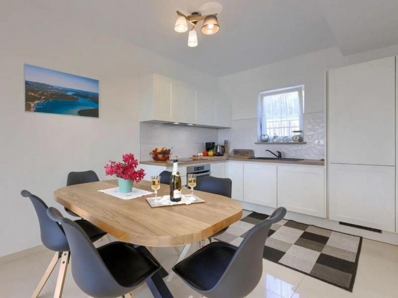 Essbereich mit Holztisch und offener Küche