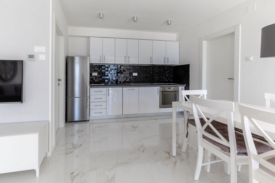 Moderne Küche mit weißer Einbauküche und Essbereich