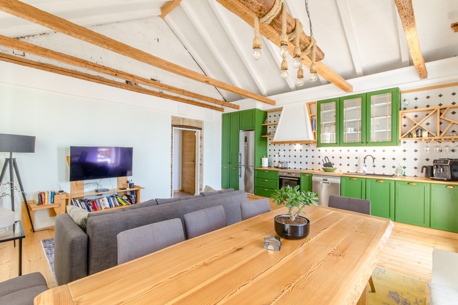Wohnbereich mit offener Küche und Holzbalkendecke