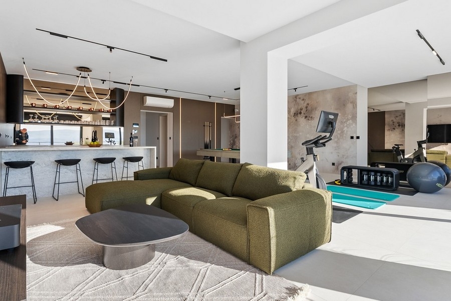 Offener Wohn- und Fitnessbereich mit Bar und Billardtisch