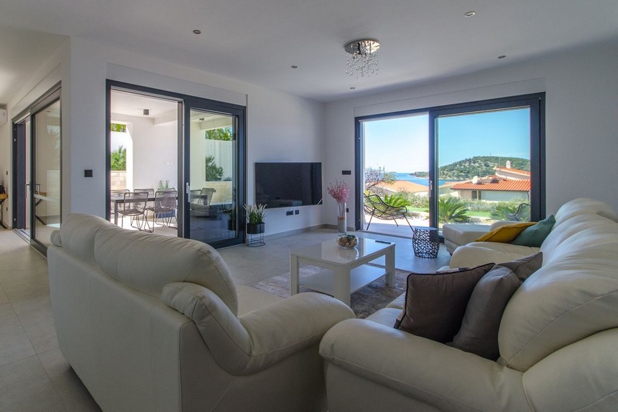 Heller Wohnbereich mit großer Glasfront und Meerblick