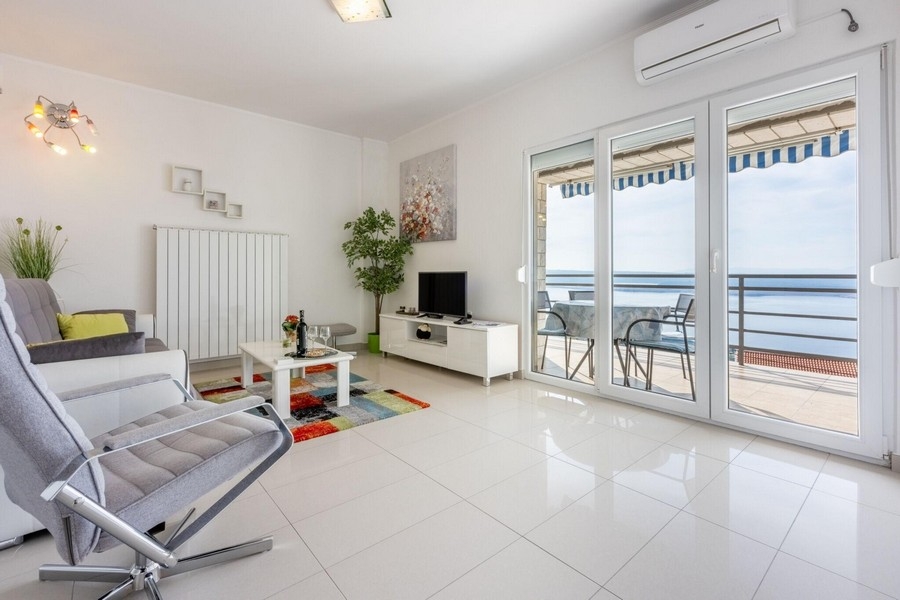 Wohnzimmer mit Balkonzugang und Meerblick