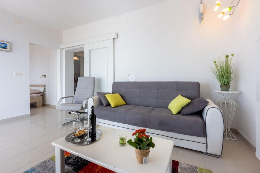 Wohnbereich mit Sofa und offenem Zugang zum Schlafzimmer