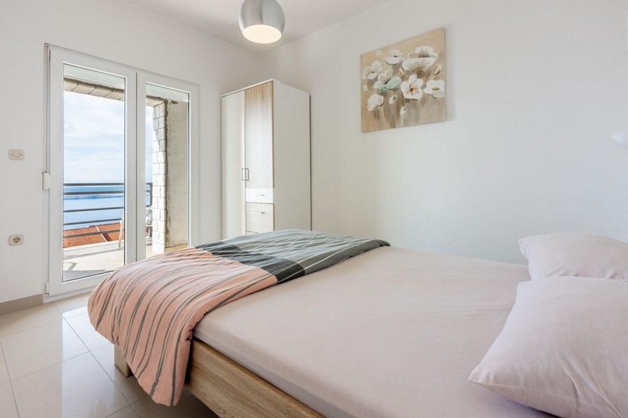 Schlafzimmer mit Doppelbett und Zugang zum Balkon