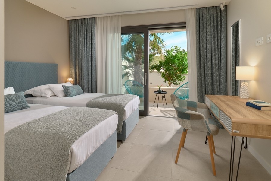 Schlafzimmer mit zwei Betten und Zugang zur Terrasse