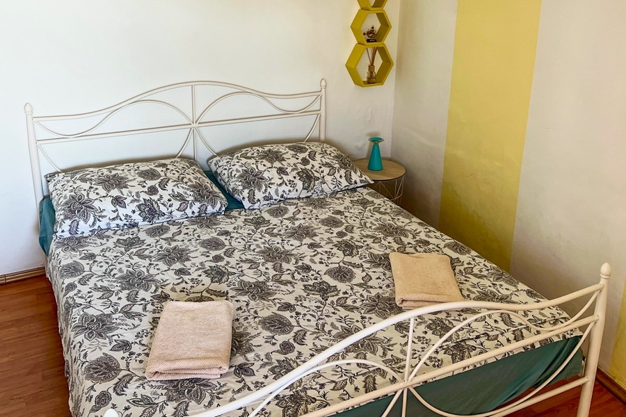 Schlafzimmer mit Metallbett und Nachttisch