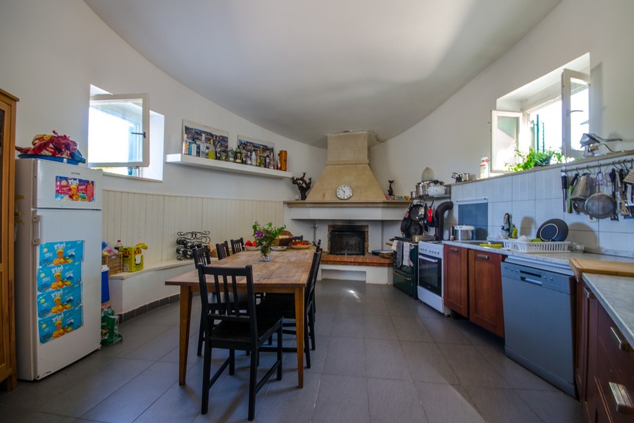 Große Küche mit Kamin und rustikalem Holztisch