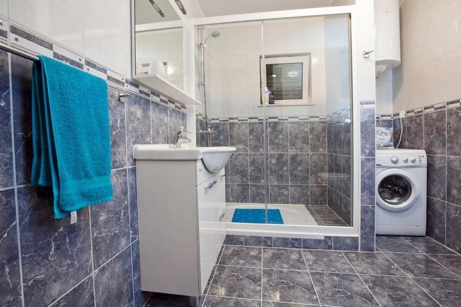 Badezimmer mit Dusche und Waschmaschine