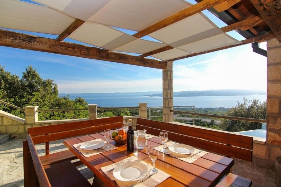 Überdachte Terrasse mit Sitzbereich und Meerblick