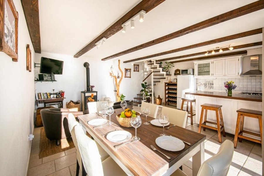 Wohnbereich mit Holzbalken, Kaminofen und Küche