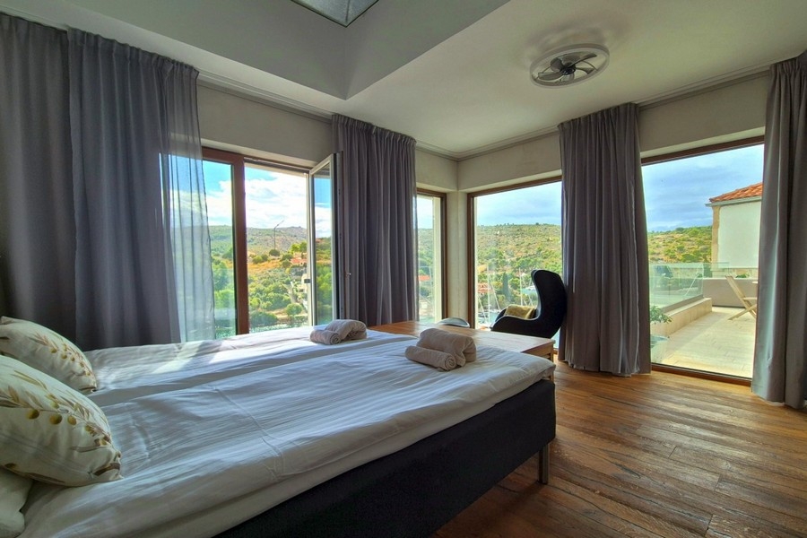 Schlafzimmer mit Panoramafenstern und Meerblick