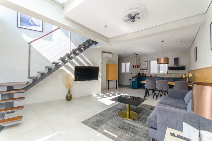 Moderner Wohnbereich mit Treppe und offener Küche