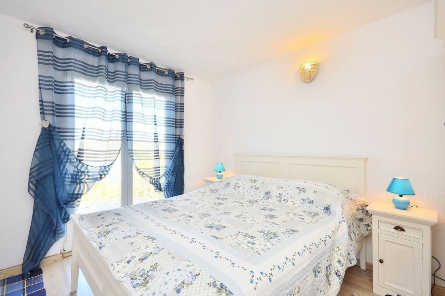 Schlafzimmer mit Doppelbett und blauen Vorhängen