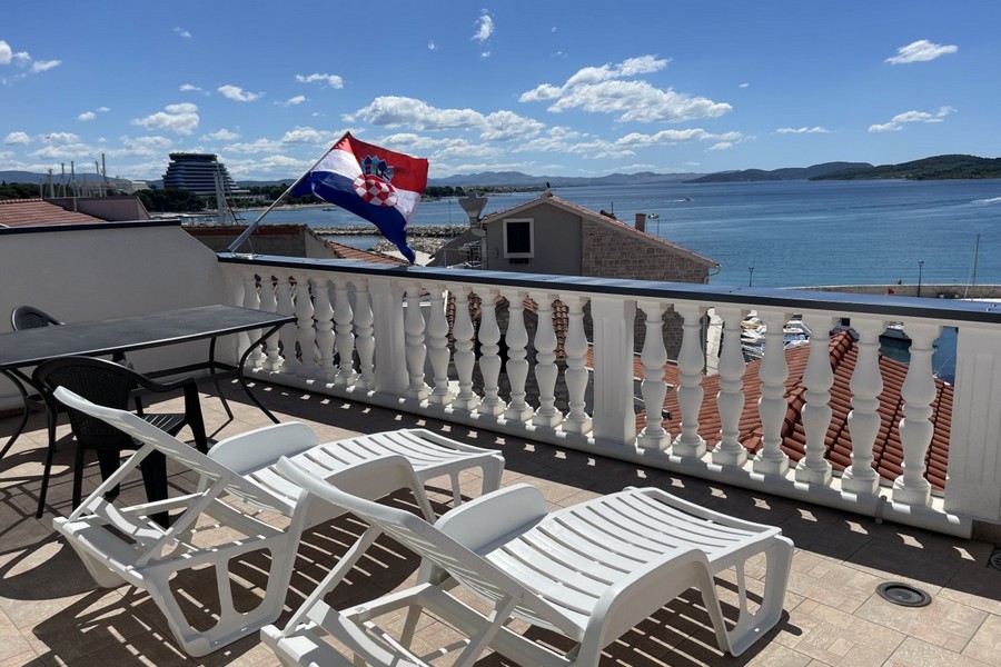 Terrasse mit Sonnenliegen und Meerblick in Kroatien