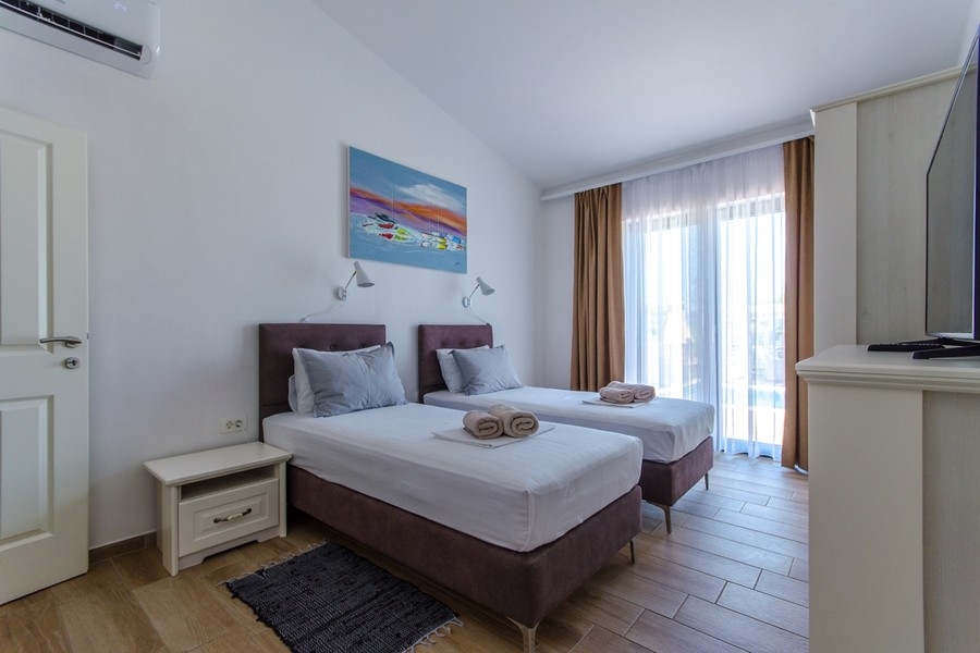 Schlafzimmer mit zwei Einzelbetten und Balkonzugang